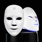 Two LED face masks on black stands with one glowing blue.