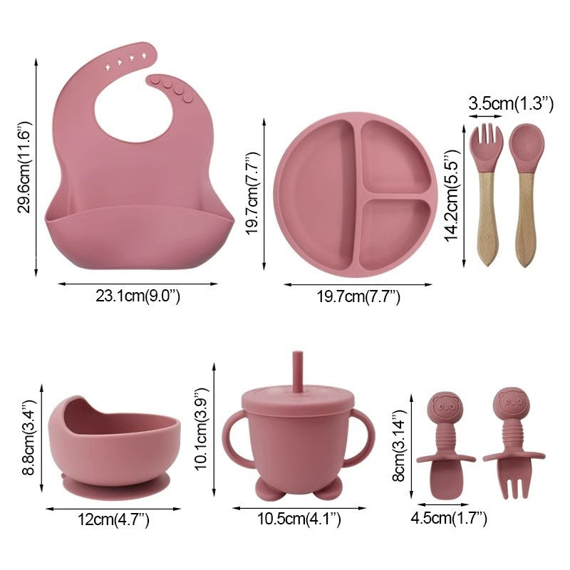 Baby feeding set with bib, plate, cup, and utensils with measurements on a white background