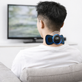 Person using a neck massager device in a living room setting.