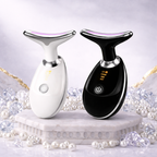 Two skin care devices, one white and one black, on a decorative stand with pearls.