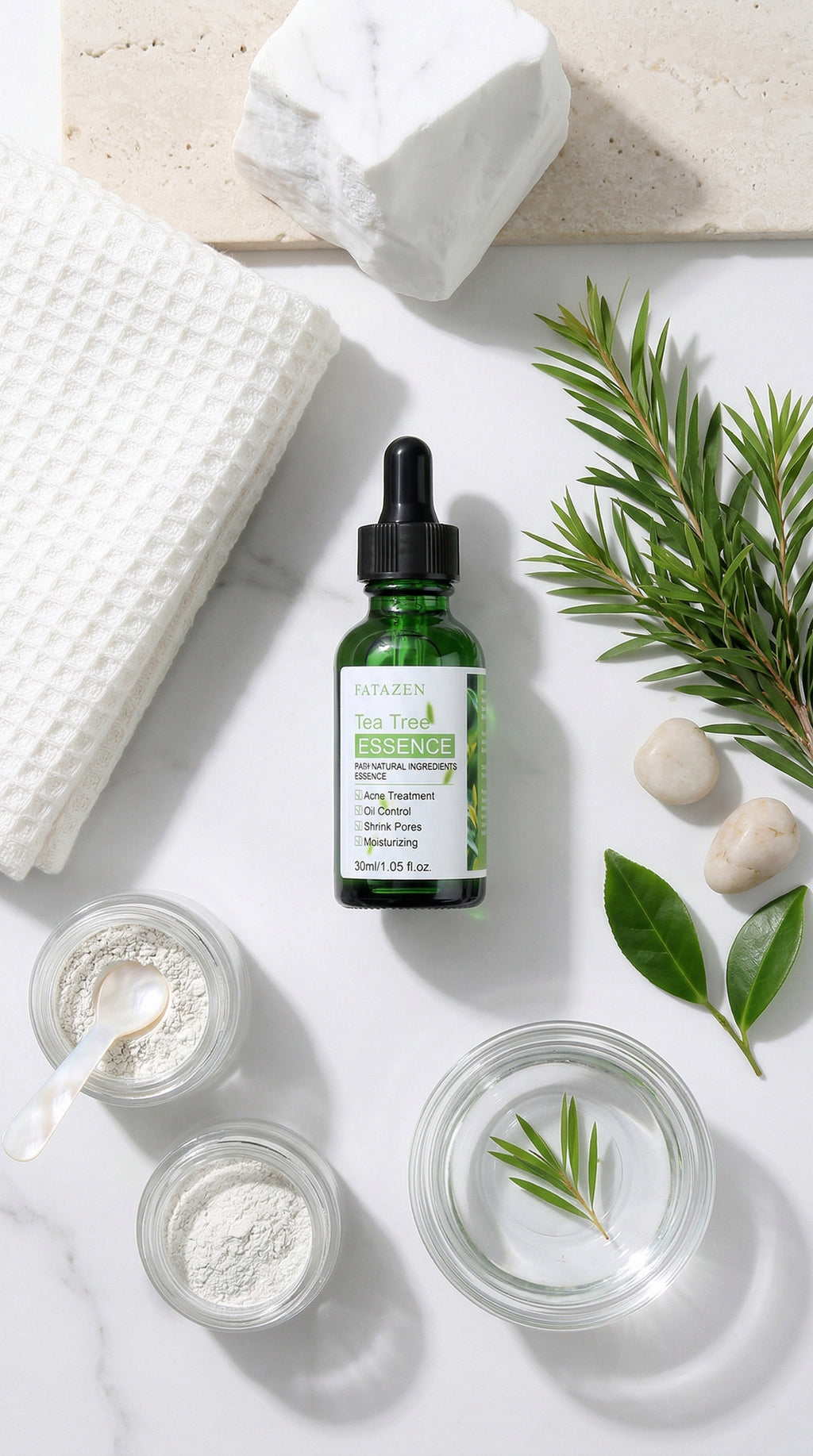Green bottle with dropper on a white surface with jars, leaves, and soap.